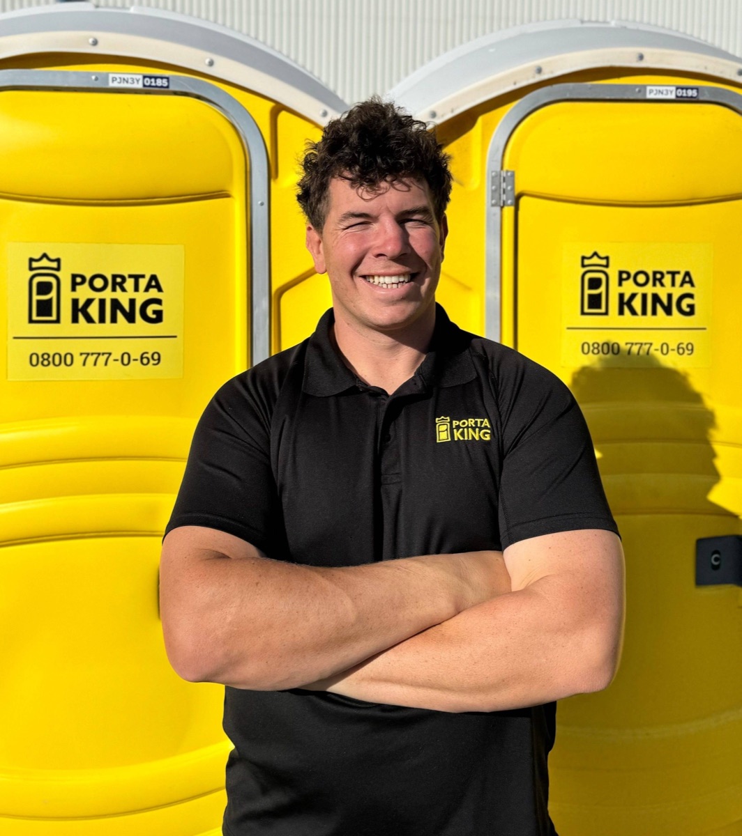 Charlie from Porta King, arms crossed in front of two yellow units